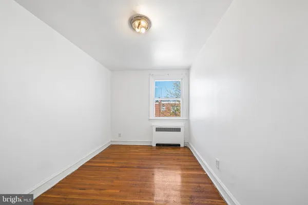 a view of a room with wooden floor and a window