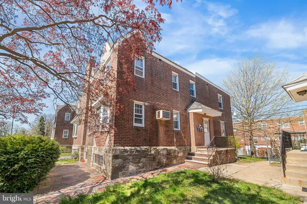a brick building that has a tree in front of it