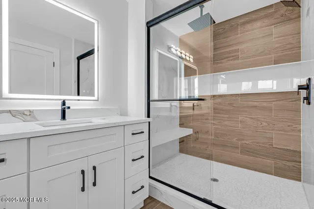 a bathroom with a shower sink and mirror