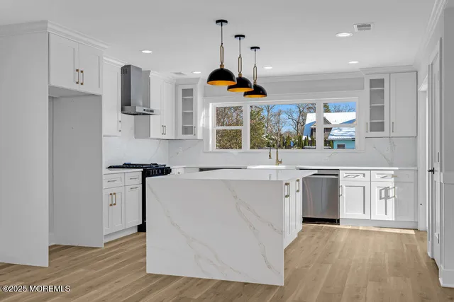 a kitchen with white cabinets and refrigerator