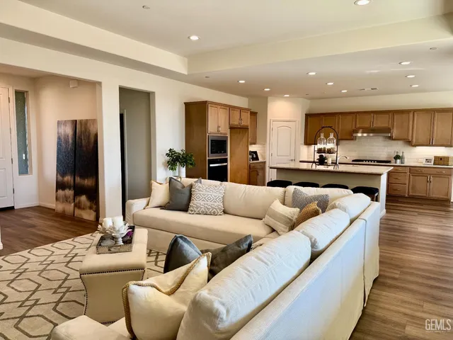 a living room with furniture kitchen view and a large window