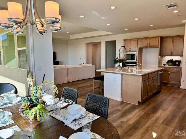 a living room with stainless steel appliances furniture and a view of kitchen