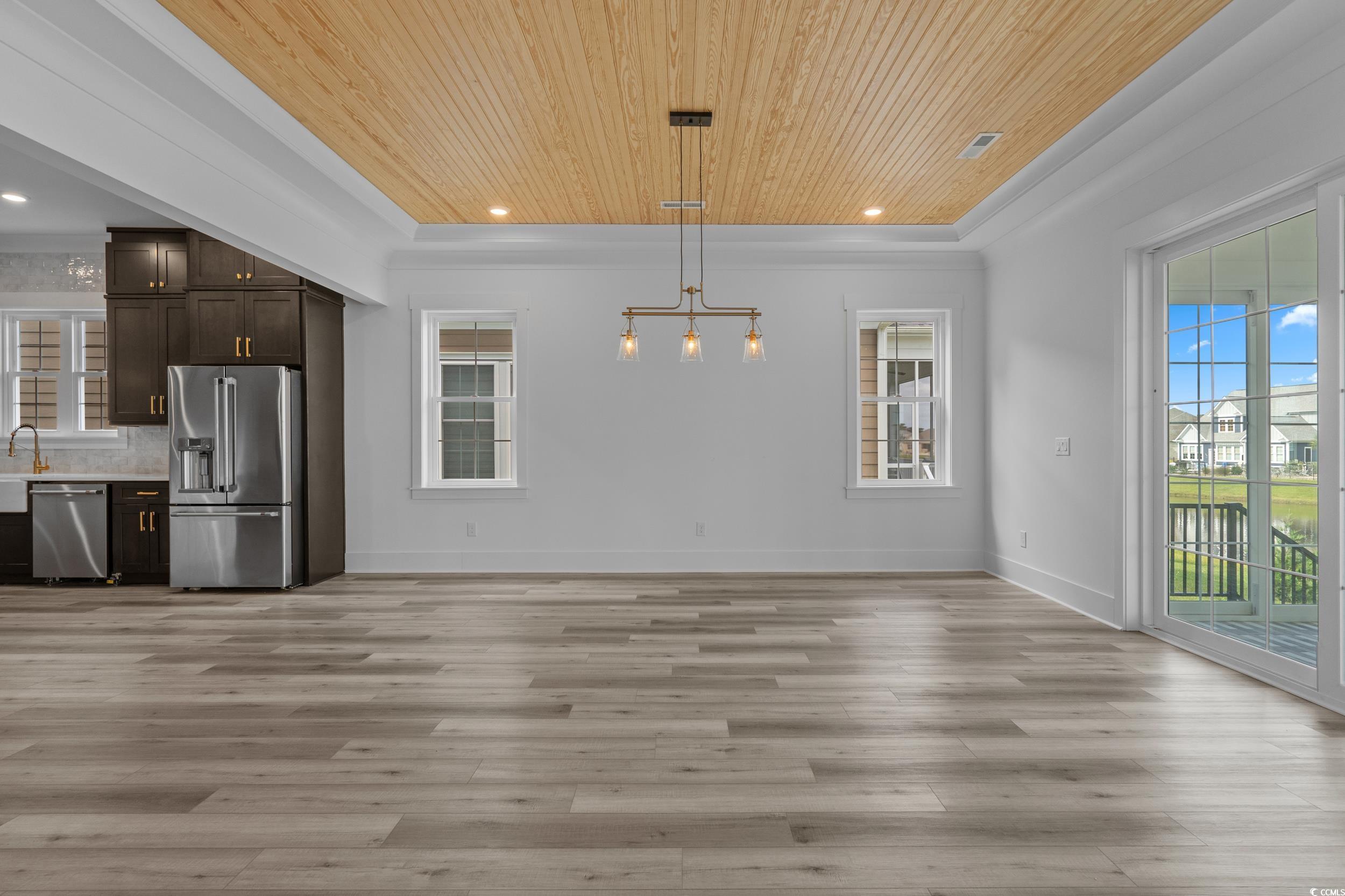 921 Crystal Water Way Myrtle Beach, SC 29579 - Photo 11 of 36 Unfurnished dining area featuring wood ceiling, recessed lighting, light wood-type flooring, and a tray ceiling