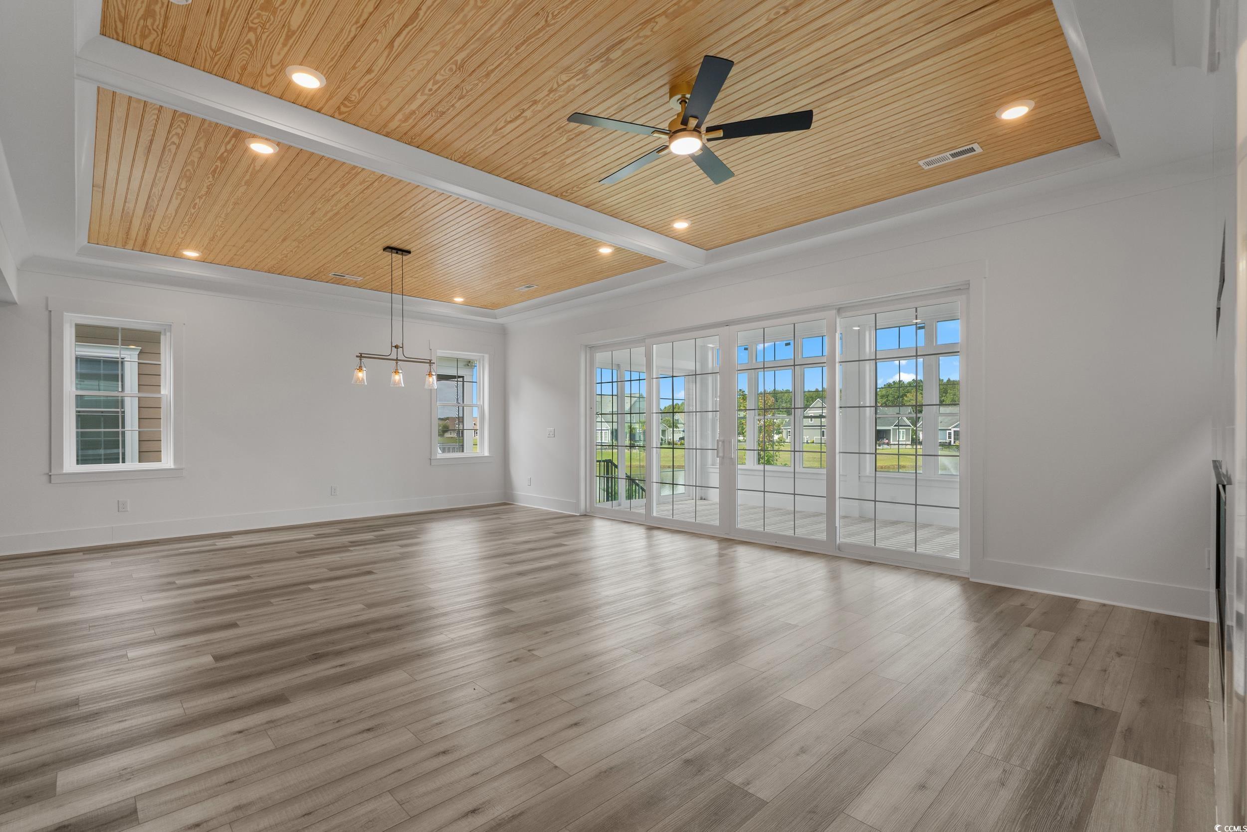 921 Crystal Water Way Myrtle Beach, SC 29579 - Photo 12 of 36 Unfurnished living room featuring wood ceiling, healthy amount of natural light, recessed lighting, light wood-style floors, and a ceiling fan