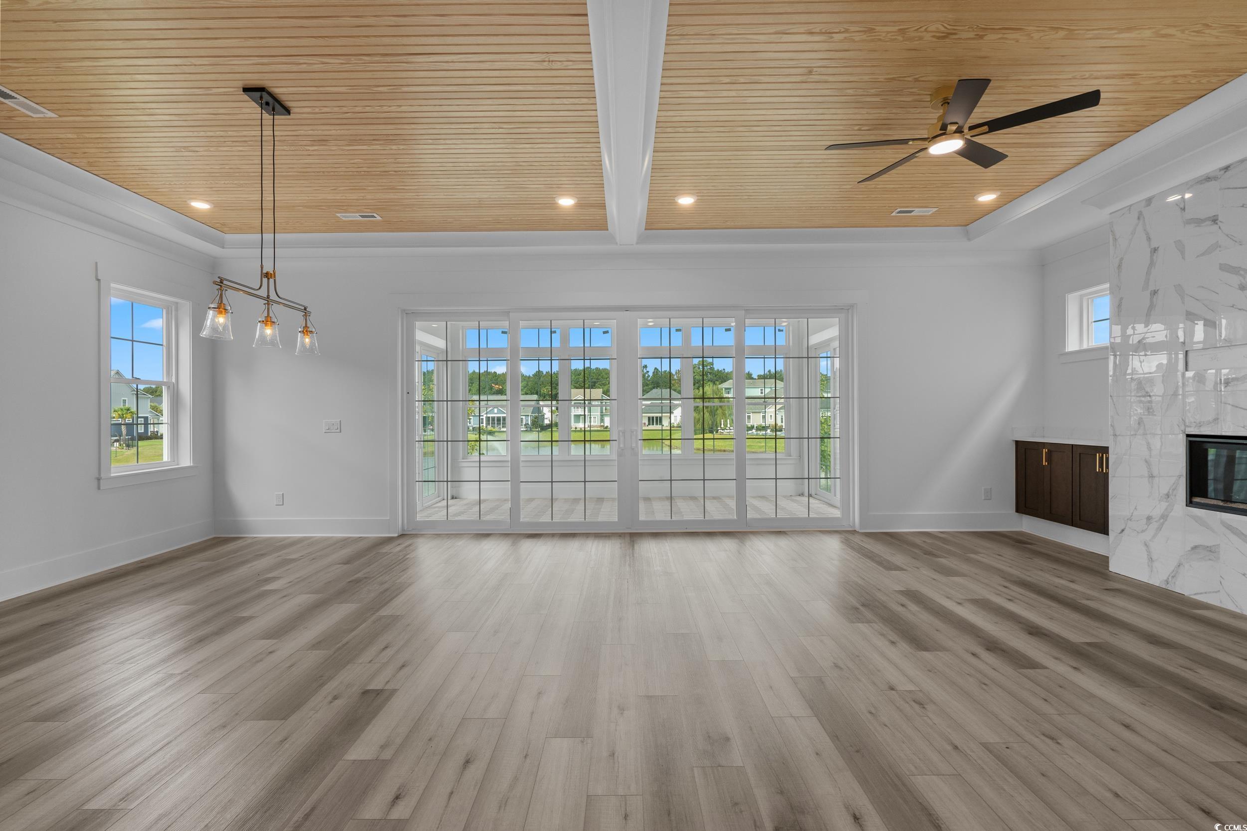 921 Crystal Water Way Myrtle Beach, SC 29579 - Photo 14 of 36 Unfurnished living room featuring a wooden ceiling with exposed beams, a fireplace, light wood-type flooring, recessed lighting, and ceiling fan