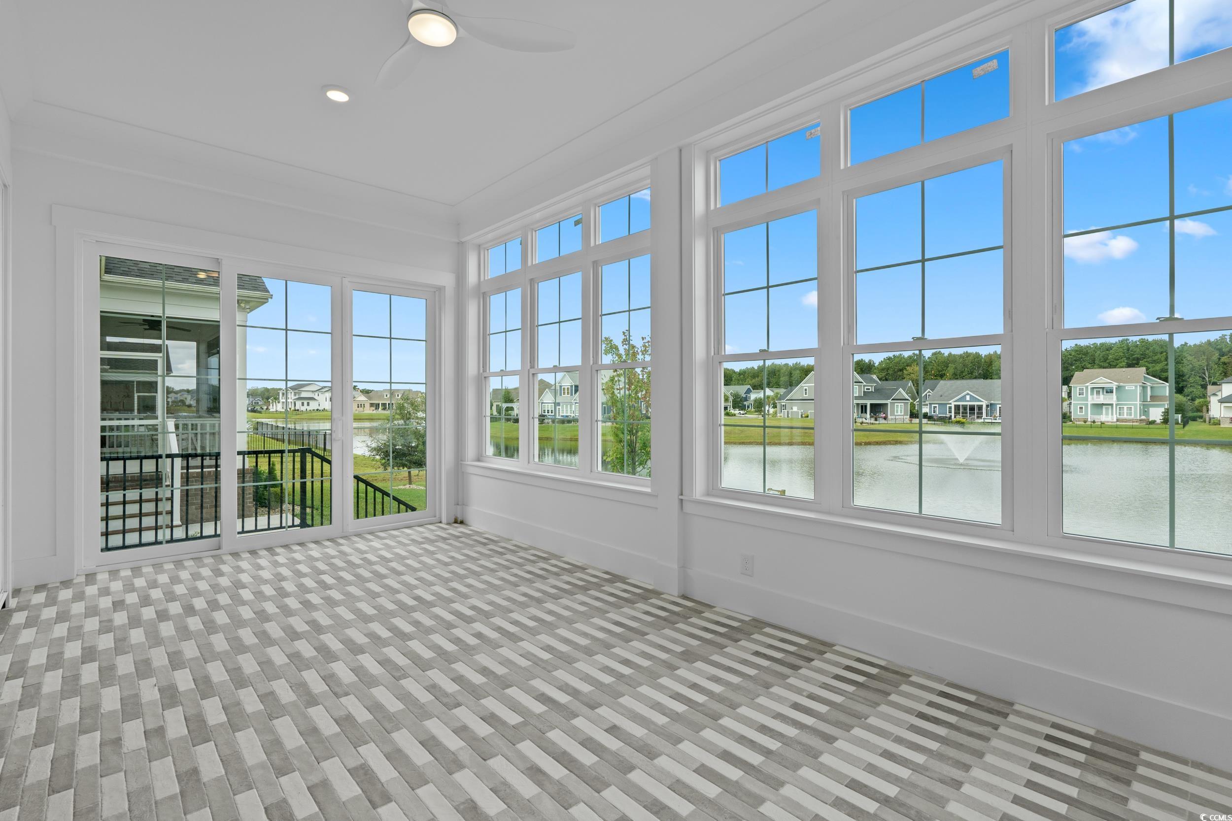 921 Crystal Water Way Myrtle Beach, SC 29579 - Photo 17 of 36 Unfurnished sunroom featuring carpet floors, a water view, a residential view, crown molding, and recessed lighting