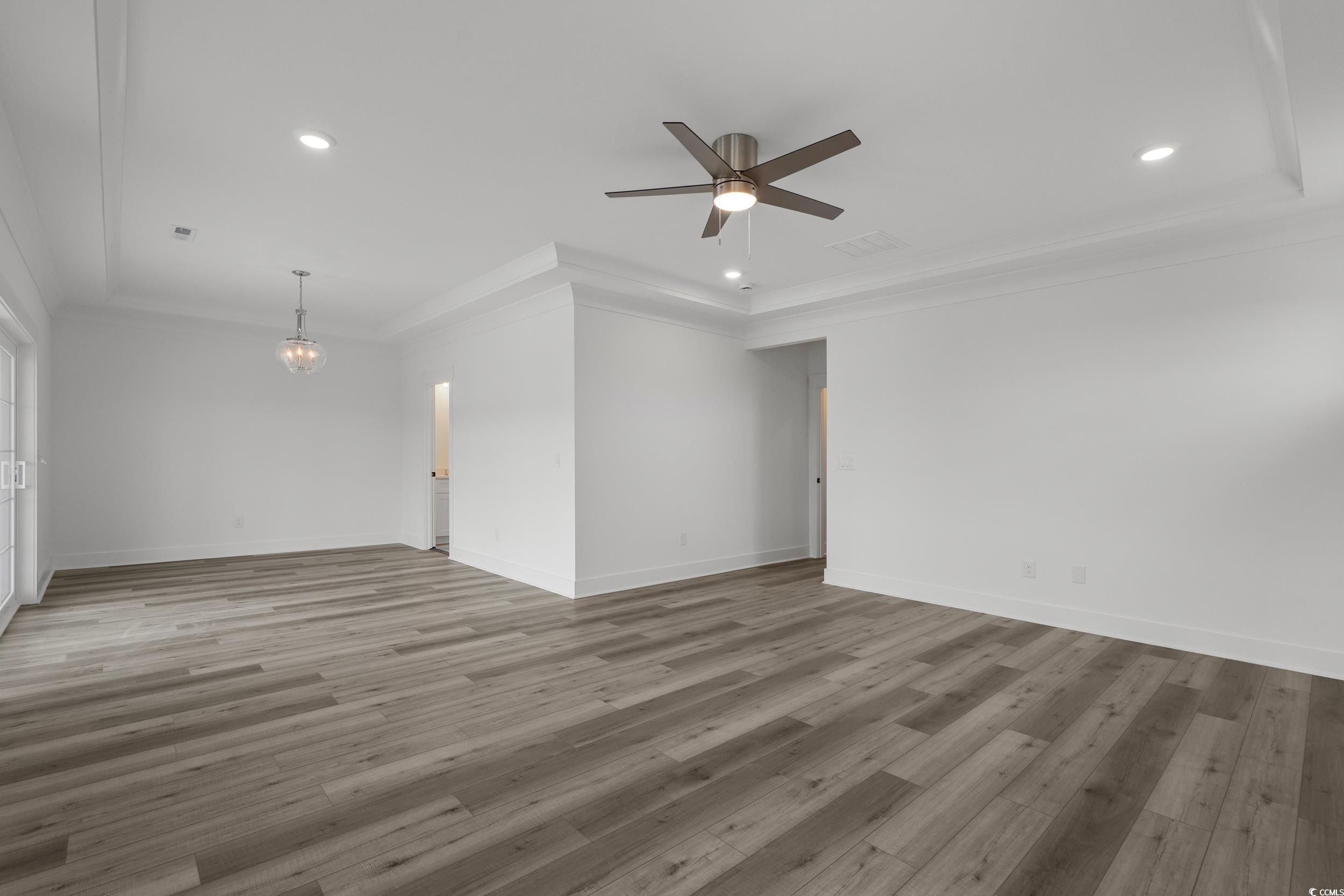 921 Crystal Water Way Myrtle Beach, SC 29579 - Photo 27 of 36 Unfurnished living room with light wood-type flooring, recessed lighting, crown molding, a chandelier, and ceiling fan