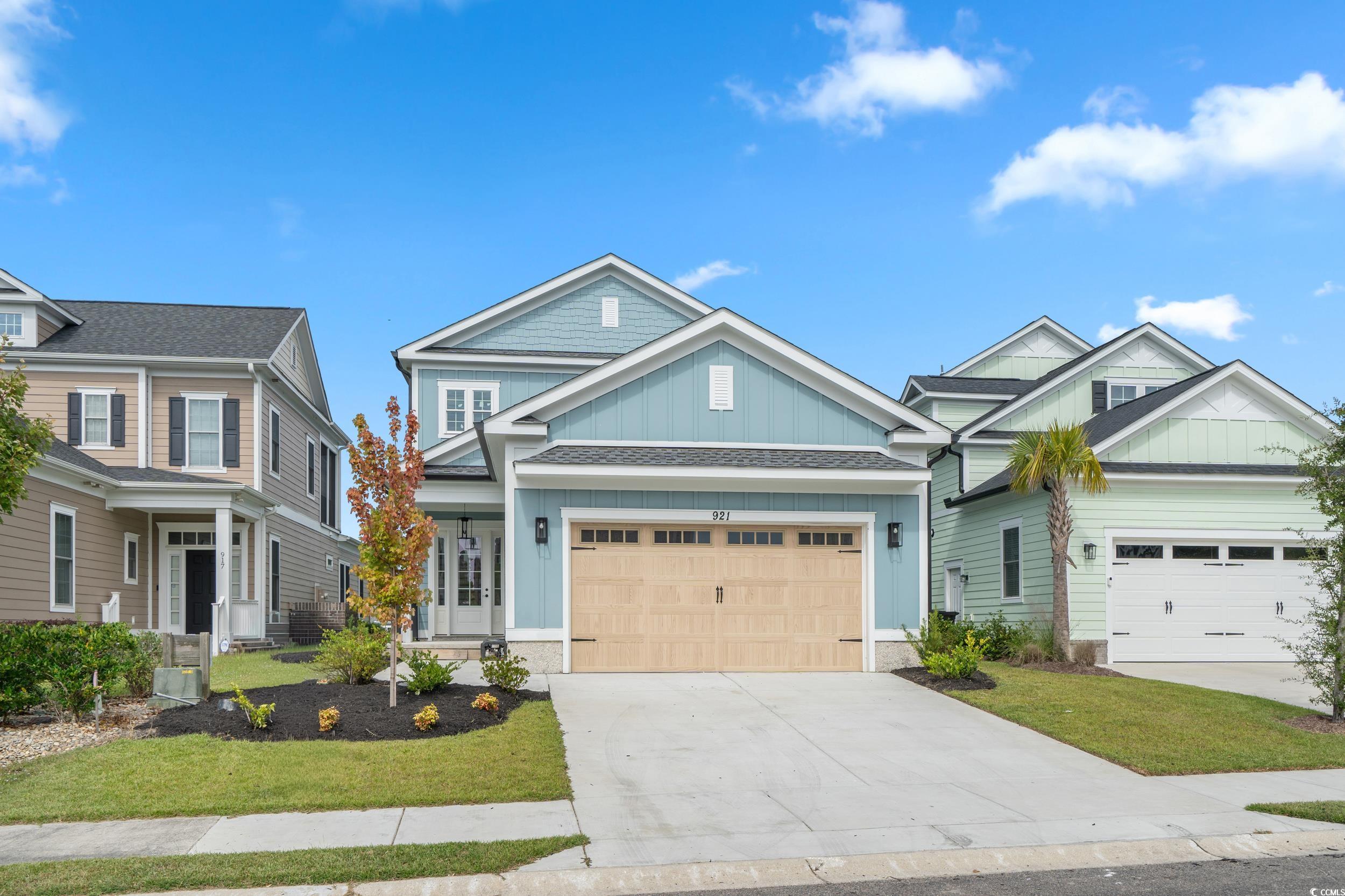 921 Crystal Water Way Myrtle Beach, SC 29579 - Photo 31 of 36 Craftsman house featuring board and batten siding, concrete driveway, a front yard, and a garage