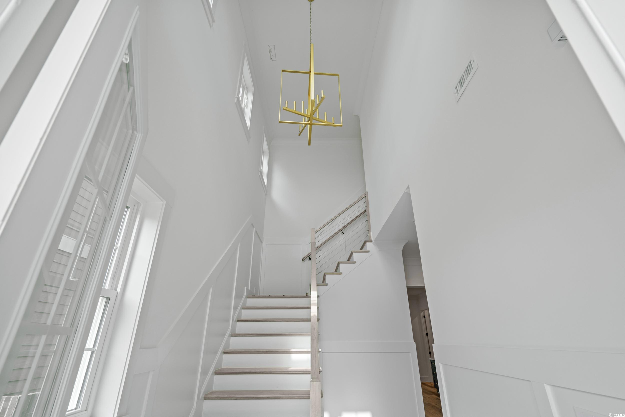 921 Crystal Water Way Myrtle Beach, SC 29579 - Photo 6 of 36 Staircase featuring a high ceiling, a chandelier, and a decorative wall
