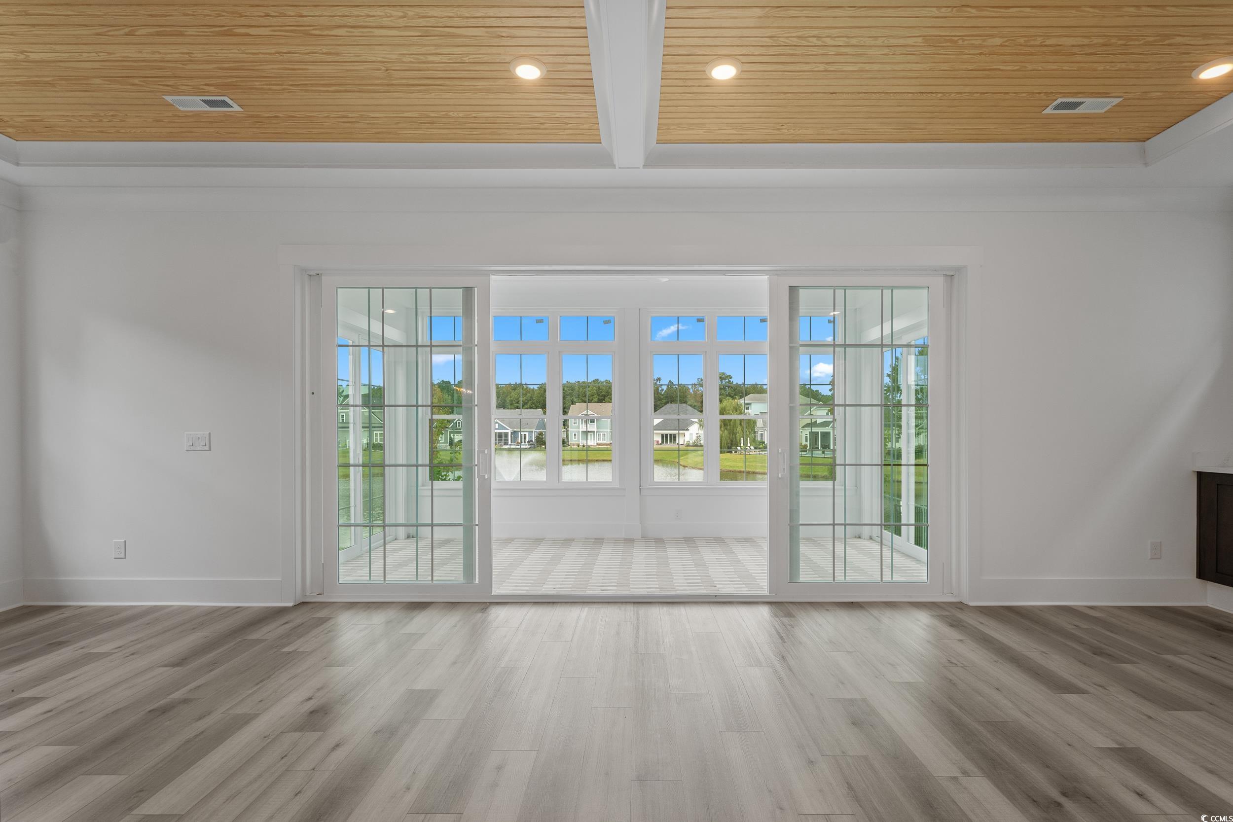 921 Crystal Water Way Myrtle Beach, SC 29579 - Photo 10 of 36 Doorway to outside featuring a wooden ceiling with exposed beams, plenty of natural light, wood finished floors, and recessed lighting