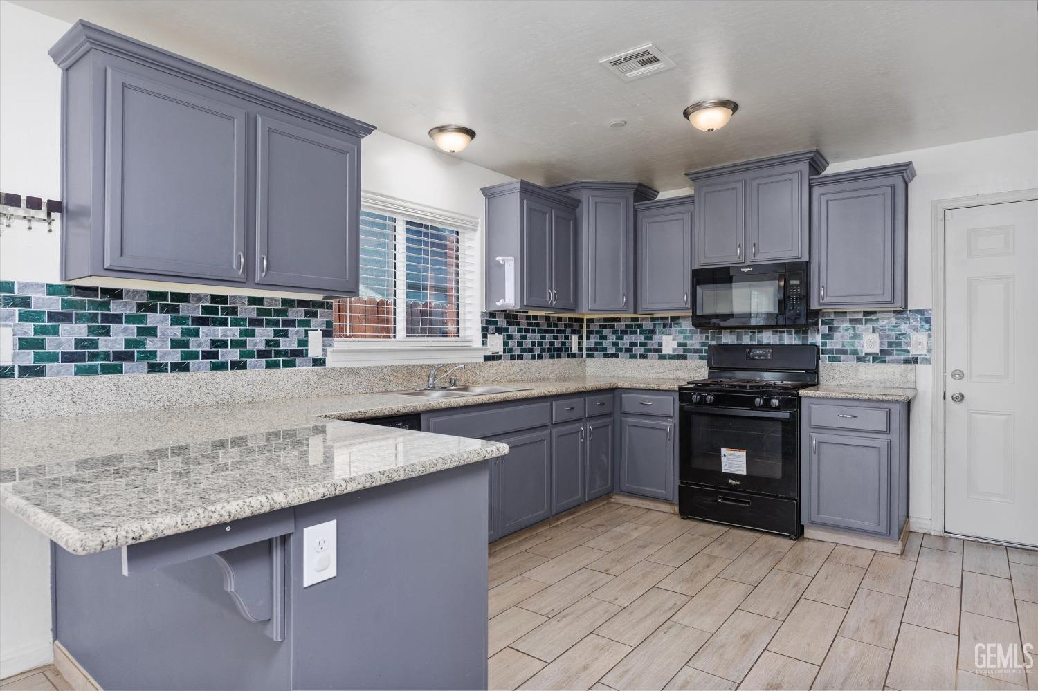 Undisclosed Address Bakersfield, CA 93307 - Photo 11 of 30 a kitchen with stainless steel appliances granite countertop a stove sink and cabinets