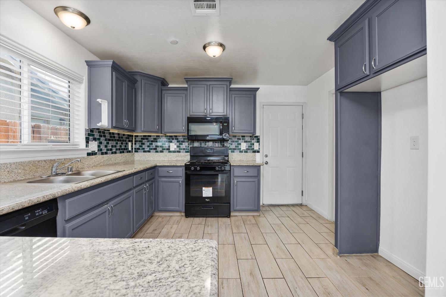 Undisclosed Address Bakersfield, CA 93307 - Photo 12 of 30 a kitchen with stainless steel appliances granite countertop a stove sink and cabinets