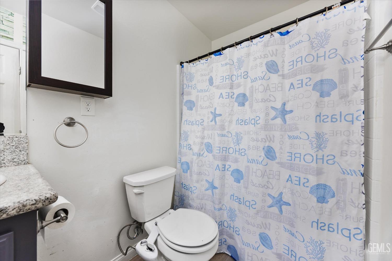 Undisclosed Address Bakersfield, CA 93307 - Photo 18 of 30 a bathroom with a granite countertop toilet a sink and a mirror