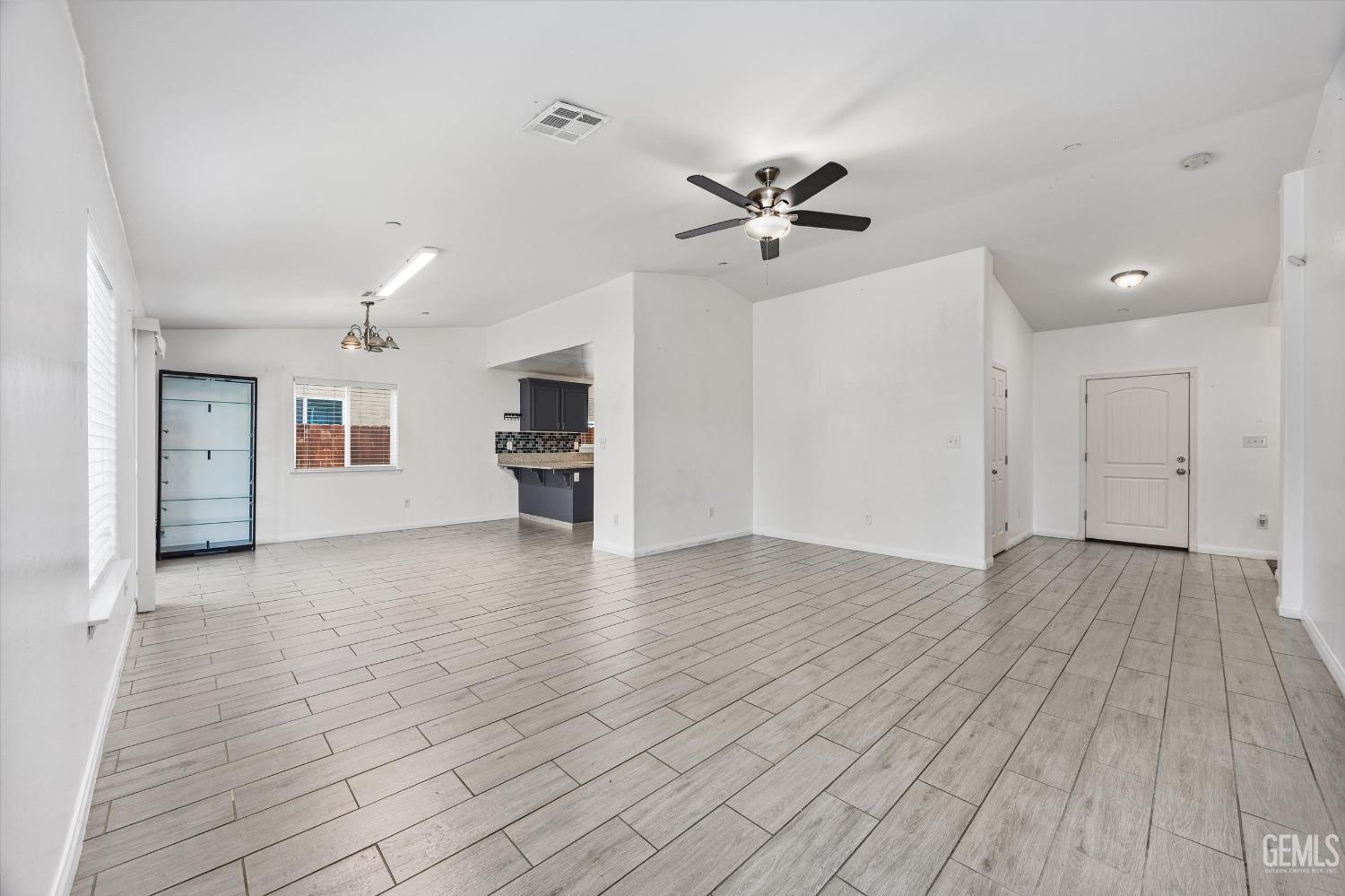 Undisclosed Address Bakersfield, CA 93307 - Photo 7 of 30 a view of empty room with wooden floor and kitchen view