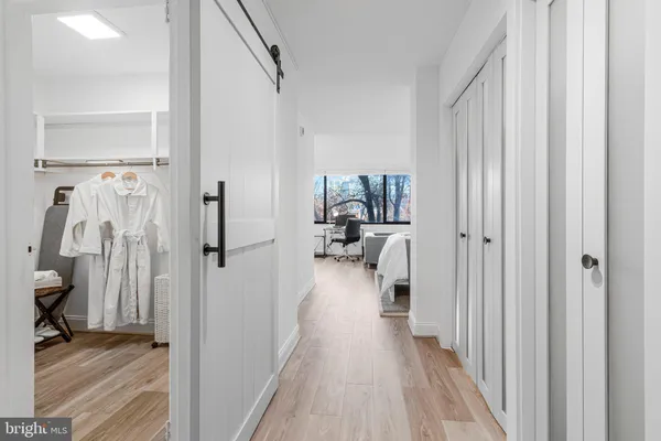 a view of a hallway with a livingroom and a hall with wooden floor