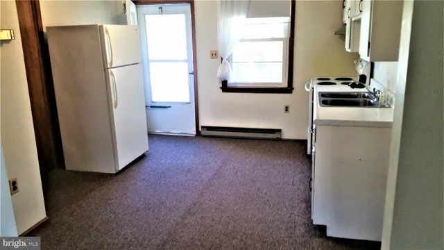 a kitchen with white cabinets and white appliances