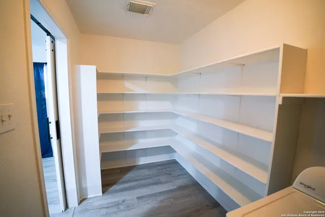 a view of walk in closet with empty racks