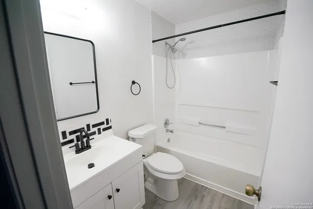 an empty room with windows and ceiling fan