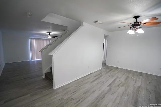 a view of empty room with wooden floor