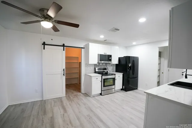 a kitchen with refrigerator cabinets and wooden floor