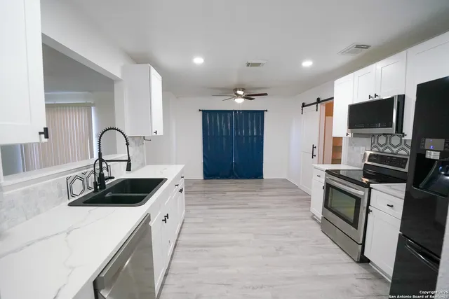 a kitchen with a sink and stainless steel appliances