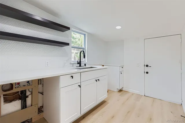 a kitchen with a sink cabinets and wooden floor