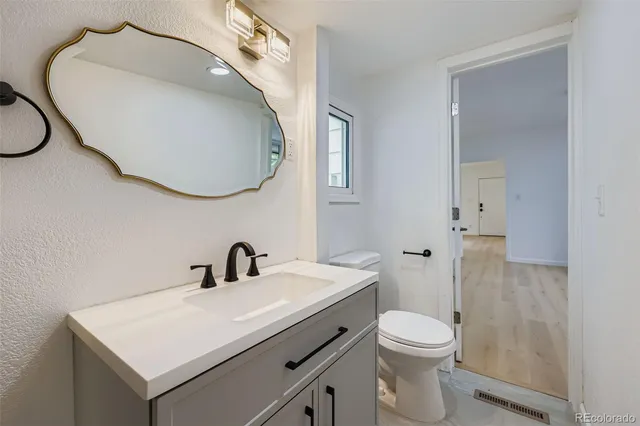 a bathroom with a toilet sink and mirror