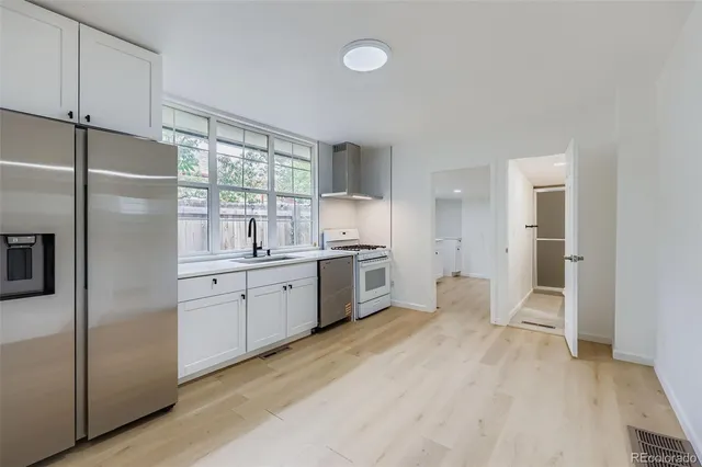 a kitchen with a refrigerator a sink and cabinets
