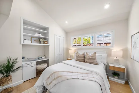 a bedroom with a large bed and a potted plant