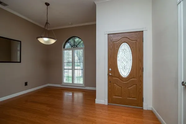 a view of a hallway with entryway wooden floor and window