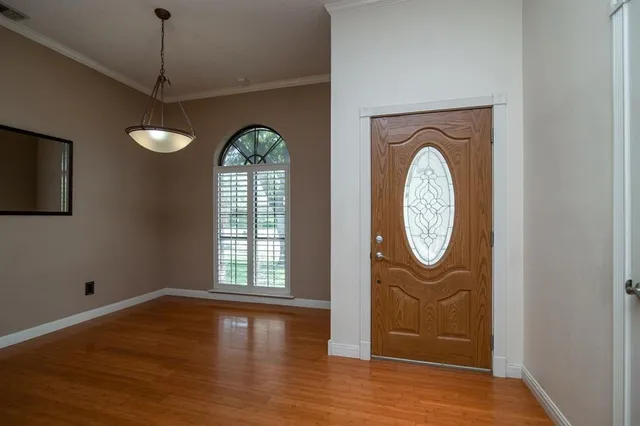 a view of a hallway with entryway wooden floor and window