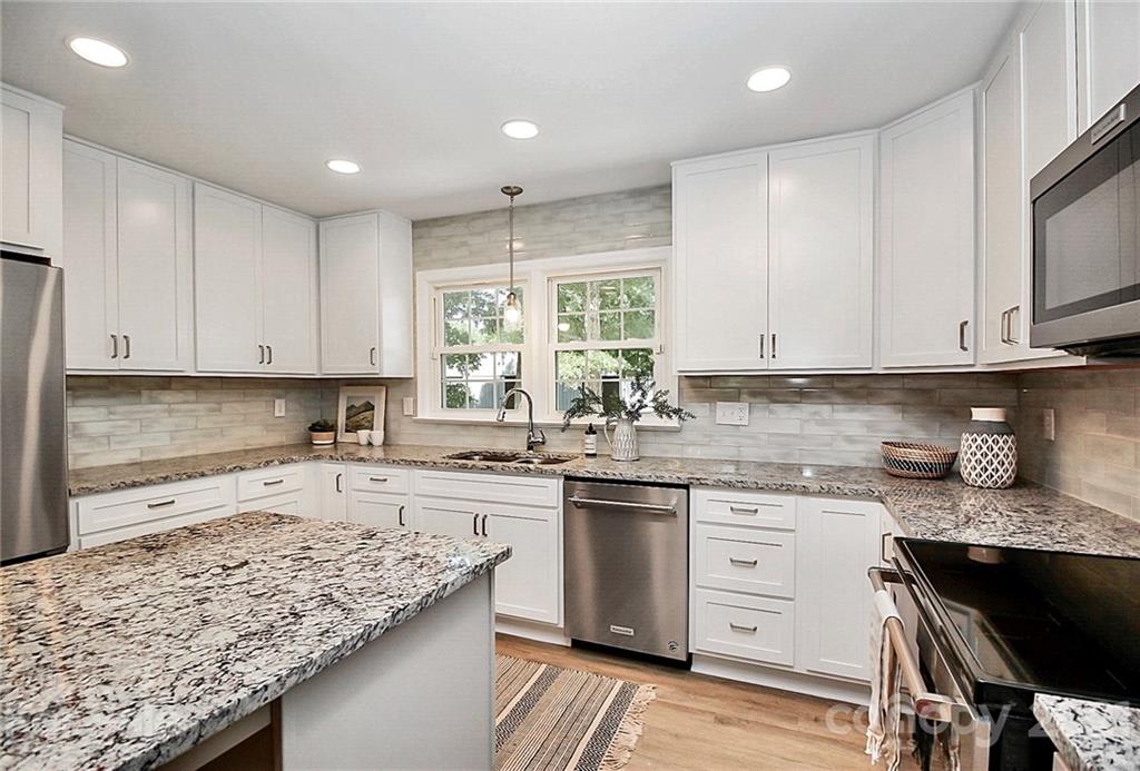 3405 Love Mill Road Monroe, NC 28110 - Photo 11 of 44 a kitchen with granite countertop white cabinets and white appliances