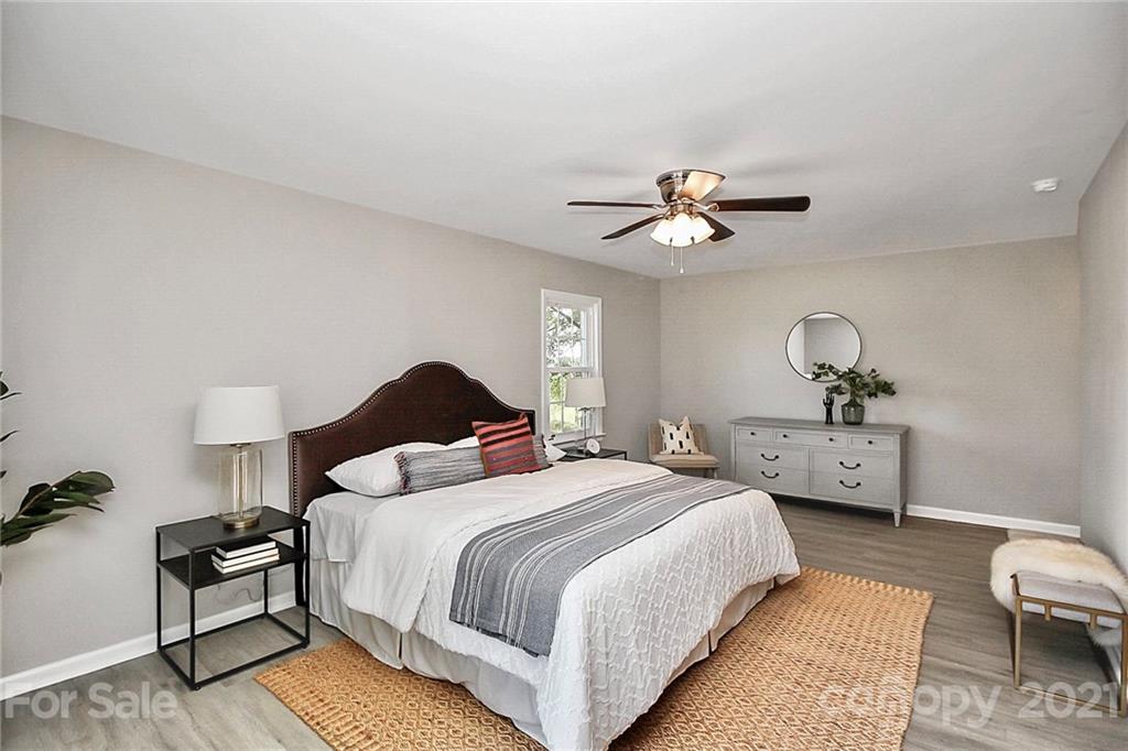 3405 Love Mill Road Monroe, NC 28110 - Photo 18 of 44 a bedroom with a bed and a chandelier