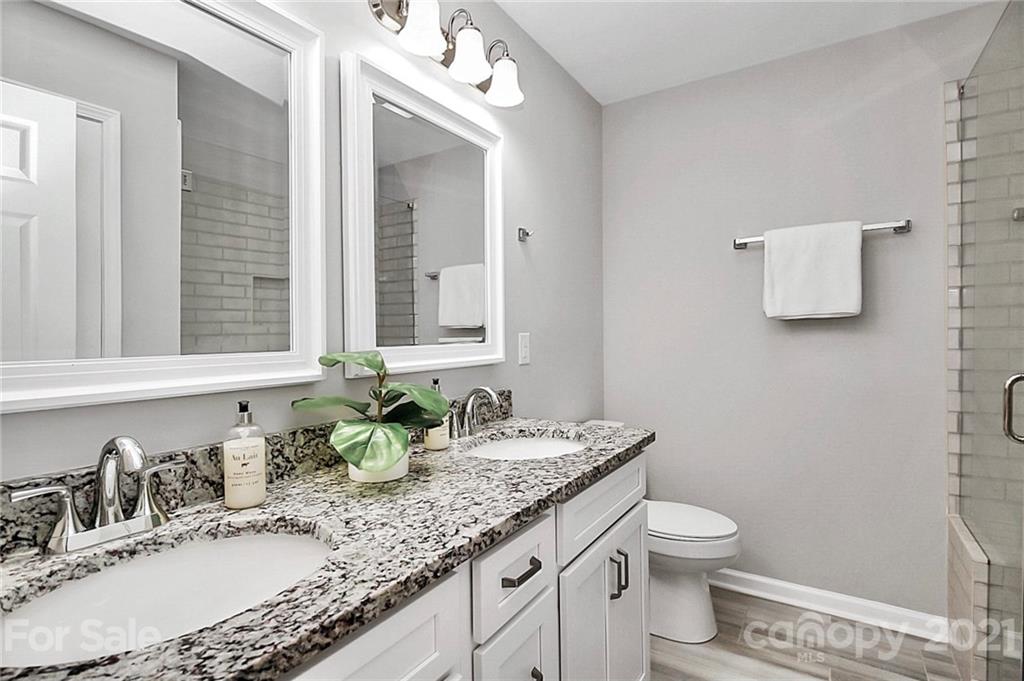 3405 Love Mill Road Monroe, NC 28110 - Photo 21 of 44 a bathroom with a granite countertop sink a large mirror and a toilet