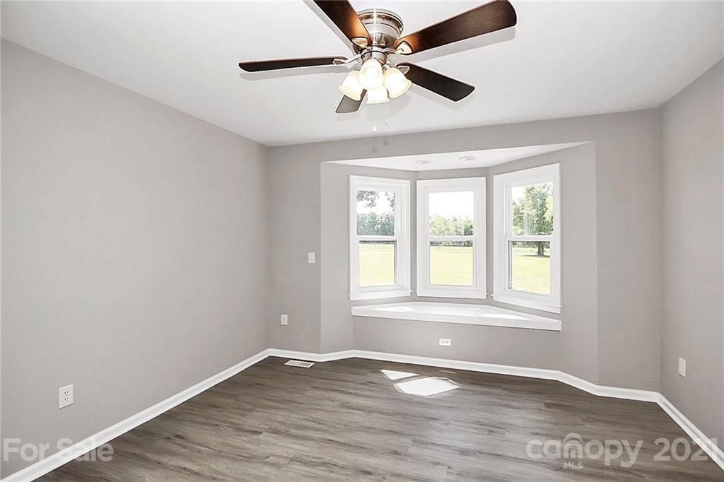 3405 Love Mill Road Monroe, NC 28110 - Photo 24 of 44 an empty room with wooden floor fan and windows