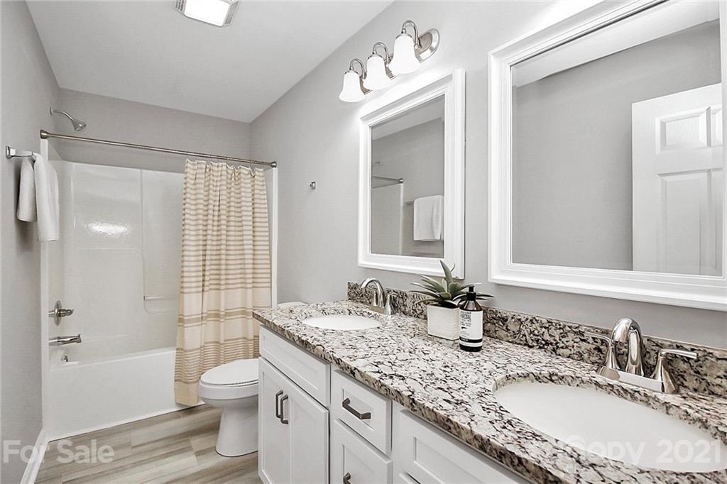 3405 Love Mill Road Monroe, NC 28110 - Photo 30 of 44 a bathroom with a granite countertop double vanity sink toilet mirror and bathtub