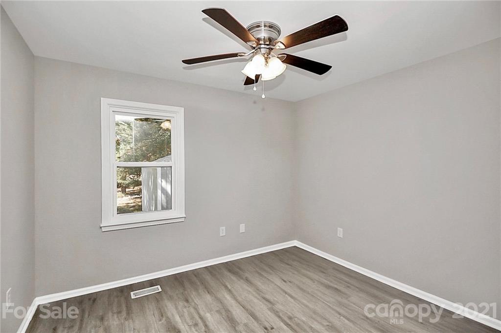 3405 Love Mill Road Monroe, NC 28110 - Photo 33 of 44 an empty room with wooden floor ceiling fan and windows