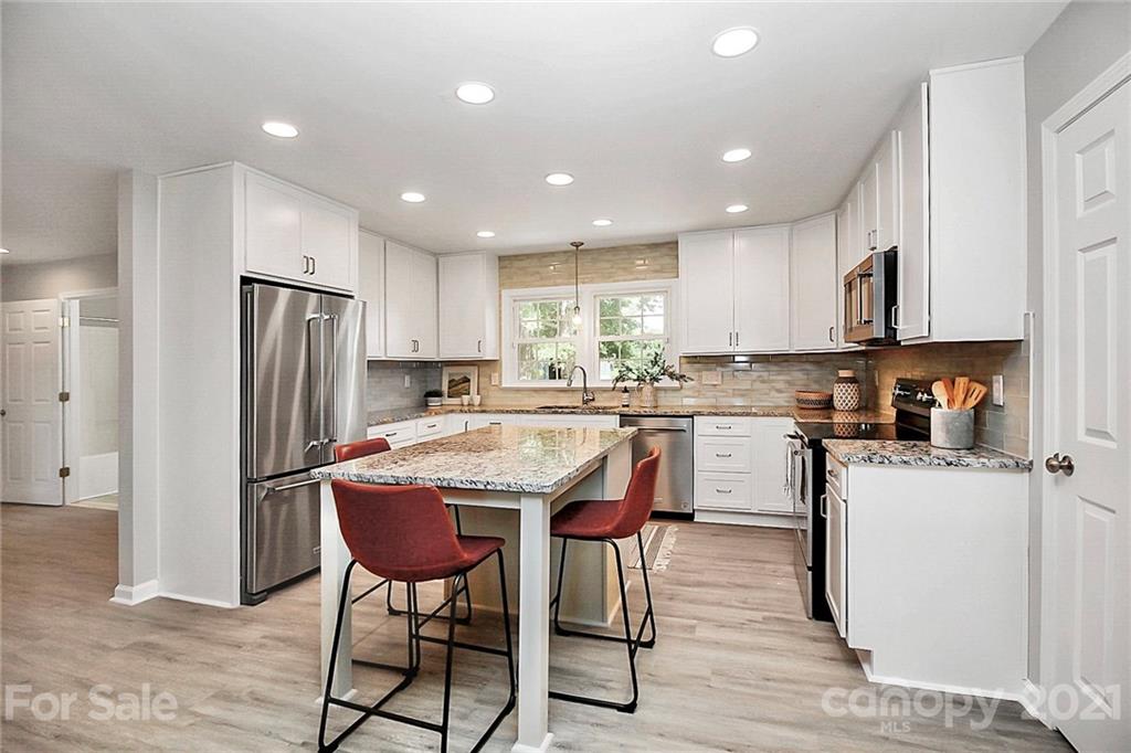 3405 Love Mill Road Monroe, NC 28110 - Photo 10 of 44 a kitchen with refrigerator and chairs