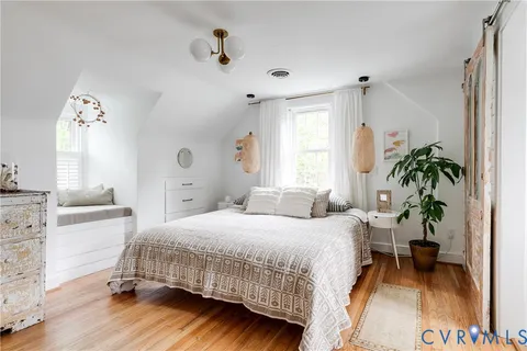 a bedroom with a bed and wooden floor