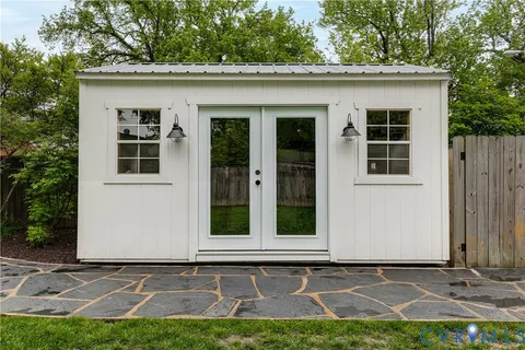 a view of a house with backyard sitting area and garden