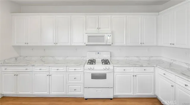 a kitchen with white cabinets and white appliances