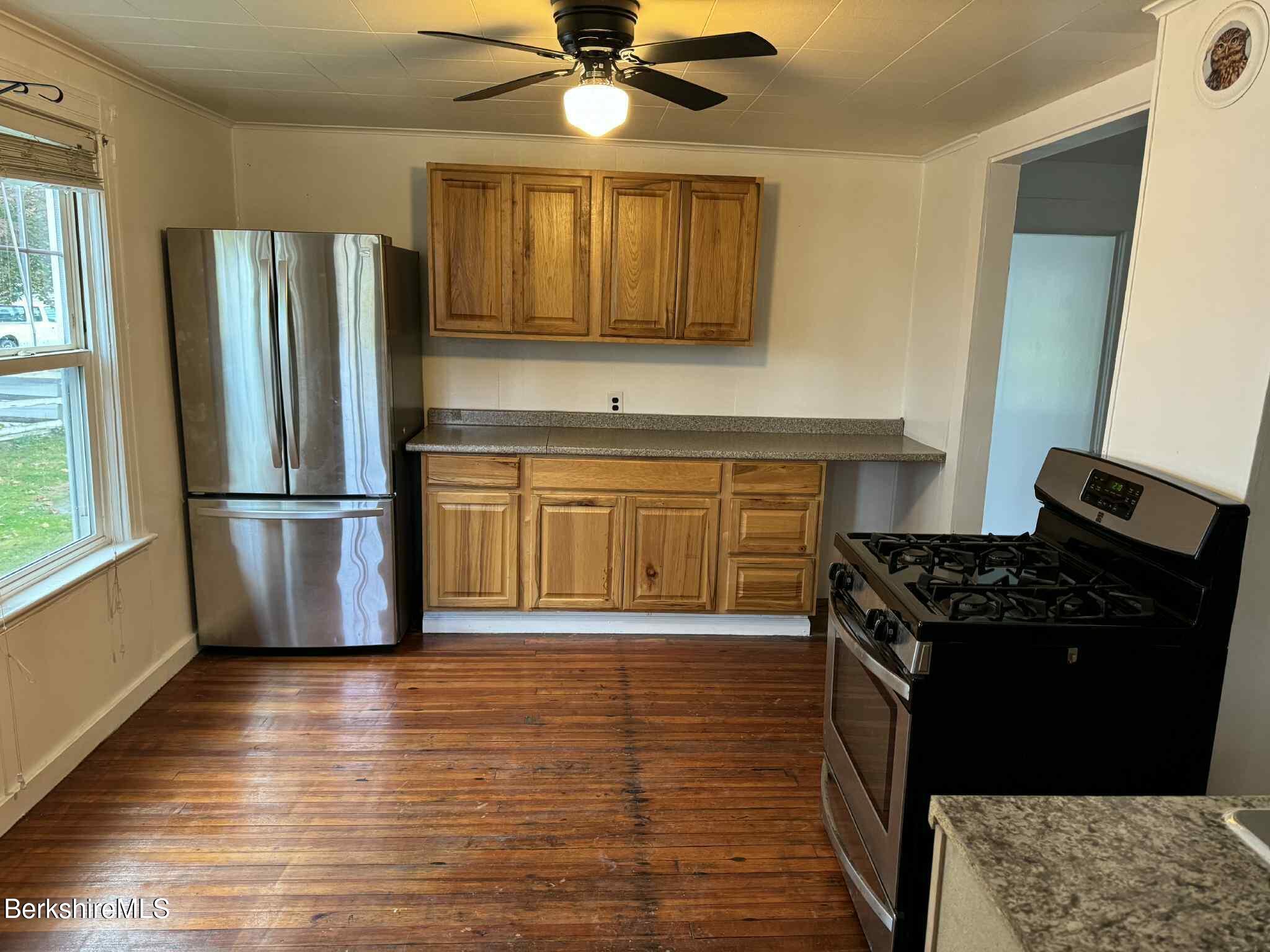 a kitchen with stainless steel appliances granite countertop a refrigerator stove top oven and sink