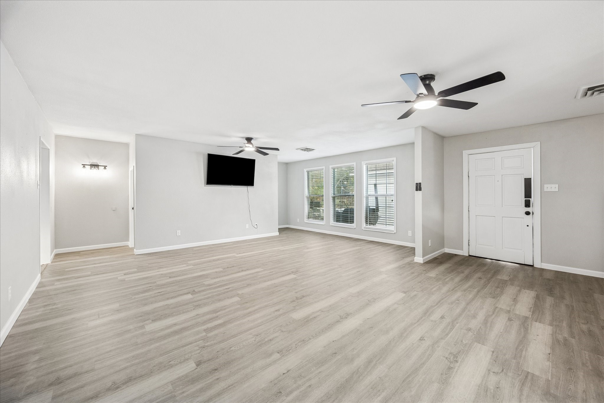 11910 11th Street Santa Fe, TX 77510 - Photo 11 of 30 a view of an empty room with wooden floor and a window