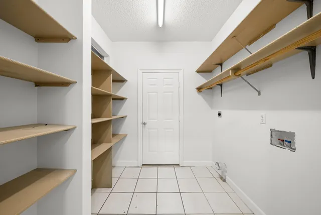 a view of walk in closet with empty racks