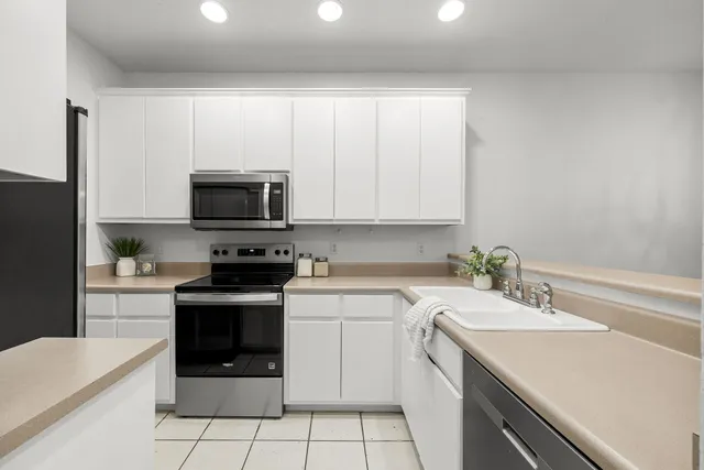 a kitchen with a sink stove and white cabinets