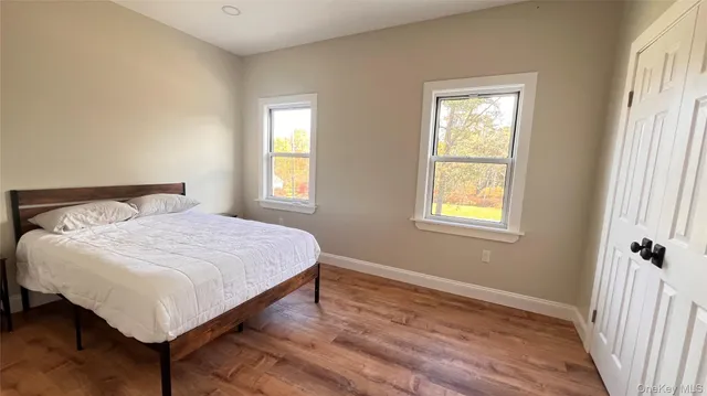 a spacious bedroom with a bed and wooden floor
