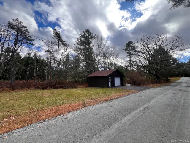 a view of a hallway with wooden floor and a living room