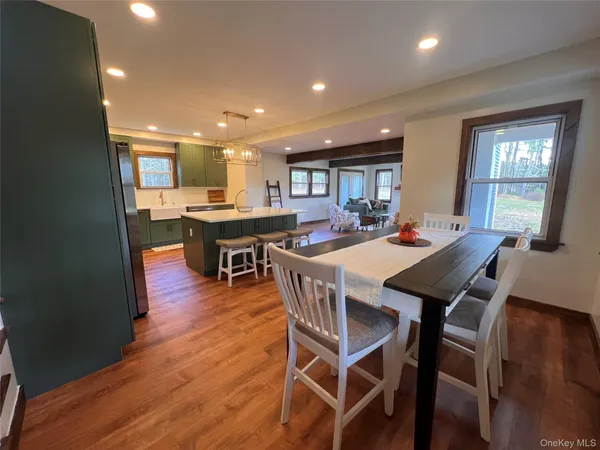 a view of a hallway with wooden floor and a living room