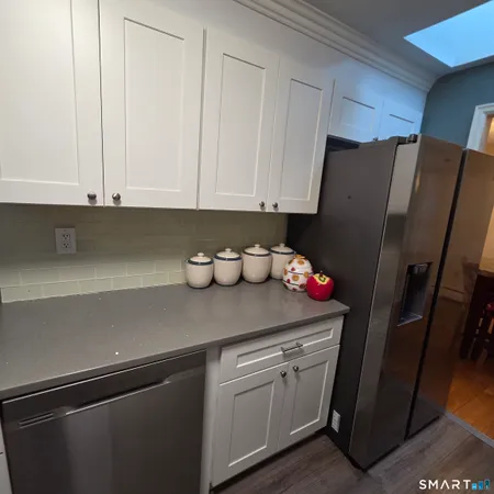 a kitchen with stainless steel appliances white cabinets and a refrigerator