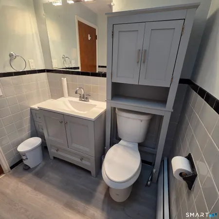 a bathroom with a toilet a sink and mirror